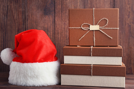Brown gift boxes with santa hat on wooden tableの写真素材