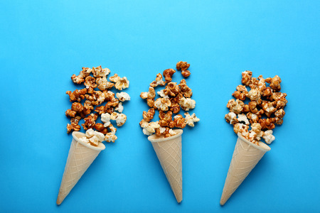 Caramel popcorn in waffle cones on blue backgroundの写真素材