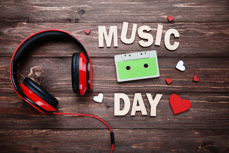Headphones with cassette tape and inscription Music Day on wooden tableの写真素材
