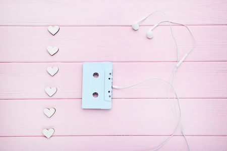 Cassette tape with earphones and white hearts on wooden tableの写真素材