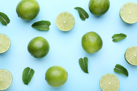Ripe limes with green leafs on blue backgroundの写真素材