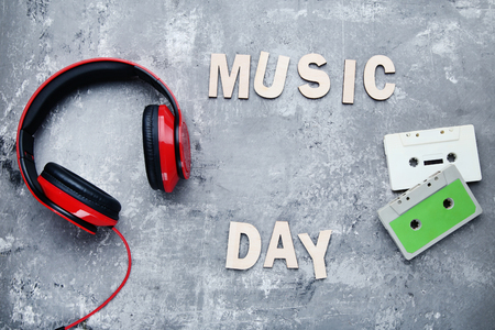 Headphones with cassette tapes and inscription Music Day on wooden tableの写真素材