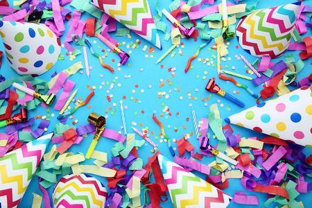 Birthday paper caps with confetti and blowers on blue backgroundの写真素材