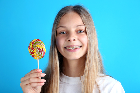 Young girl with lollipop on blue backgroundの写真素材