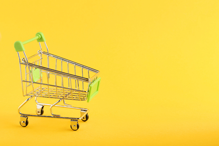 Shopping cart on yellow backgroundの写真素材
