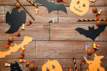 Halloween candies with paper decorations on brown wooden tableの写真素材