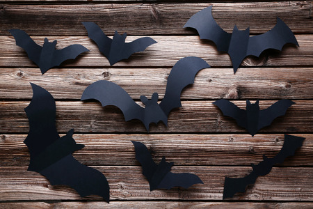 Halloween paper bats on brown wooden backgroundの写真素材