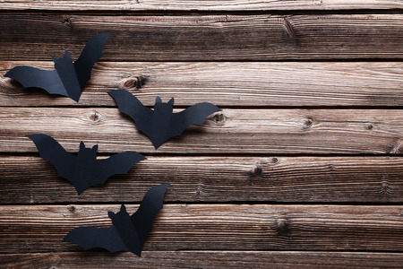 Halloween paper bats on brown wooden backgroundの写真素材