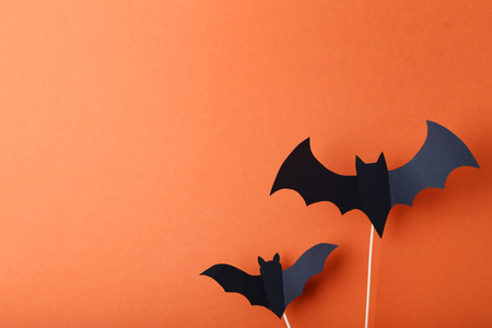 Halloween paper bats on orange background