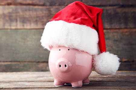 Red santa hat with piggy bank on grey wooden tableの写真素材