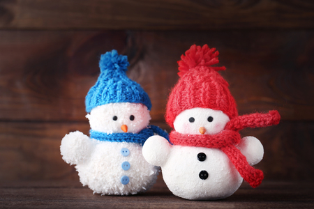 Small snowman toys on brown wooden tableの写真素材