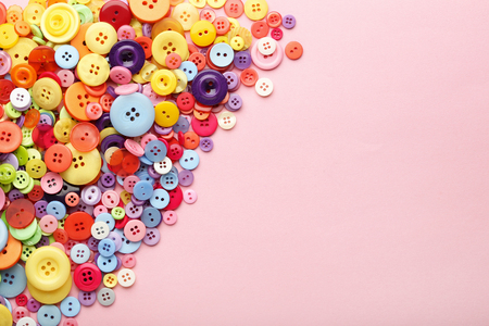 Colorful sewing buttons on pink backgroundの写真素材
