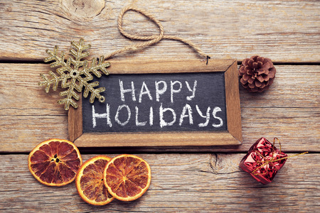 Inscription Happy Holiday on wooden frame with sliced orangesの写真素材