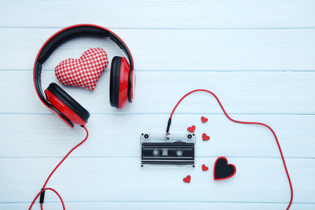 Headphones and cassette tape and red hearts on wooden tableの写真素材