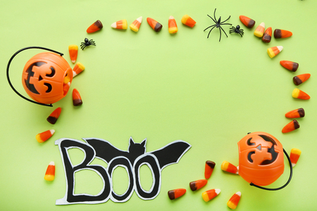 Halloween candy corns and pumpkin bucket on green backgroundの写真素材