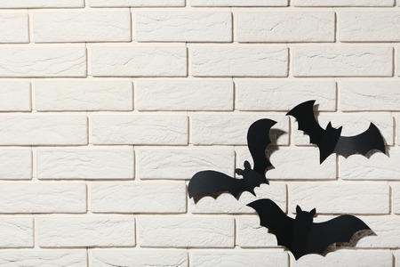 Halloween paper bats on white brick wall backgroundの写真素材