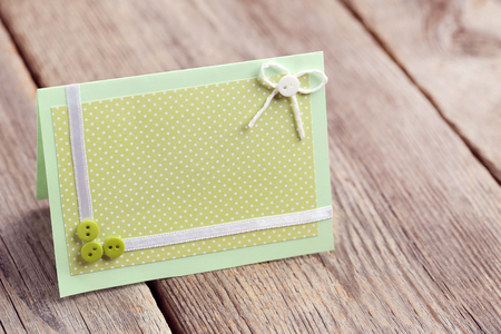 Green greeting card on grey wooden tableの写真素材