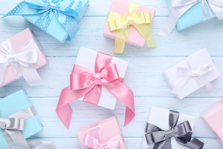 Colorful gift boxes with ribbon on wooden tableの写真素材