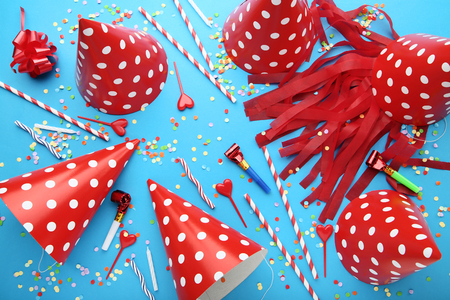 Birthday paper caps with straws, candles and blowers on blue backgroundの写真素材