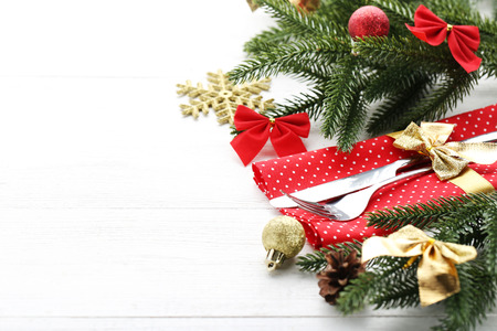 Kitchen cutlery with napkin and christmas decorations on wooden tableの写真素材
