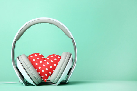 White headphones with red fabric heart on mint backgroundの写真素材