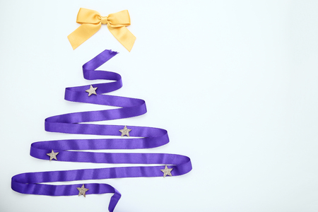 Purple ribbon in shape of christmas tree on white backgroundの写真素材
