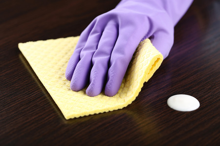 Hand in glove cleaning kitchen tableの写真素材