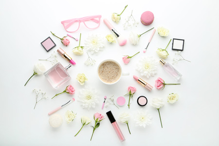Flowers with cup of coffee and makeup cosmetics on white backgroundの写真素材
