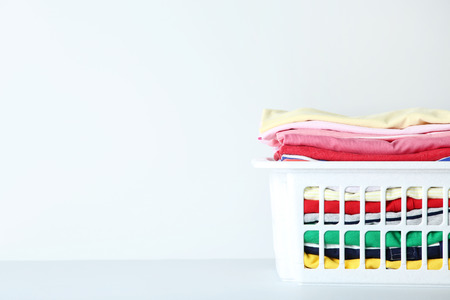 Stack of folded clothes in basket on grey backgroundの写真素材
