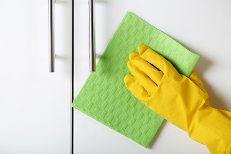 Hand in glove cleaning kitchen cabinetの写真素材