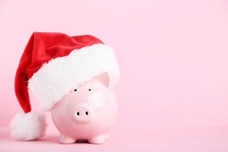Pink piggybank with santa hat on pink backgroundの写真素材