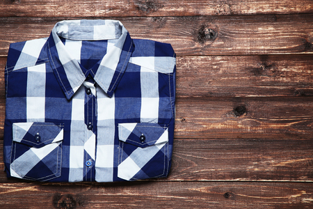 Folded shirt on brown wooden tableの写真素材