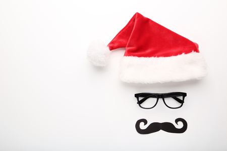 Red santa hat with glasses and paper mustache on white backgroundの写真素材