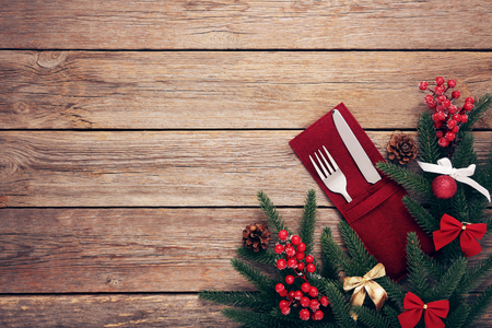 Kitchen cutlery with napkin and christmas decorations on wooden tableの写真素材