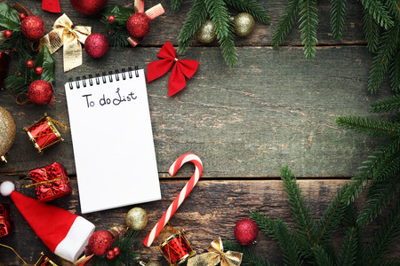 To do list in notepad with christmas decorations on wooden tableの写真素材