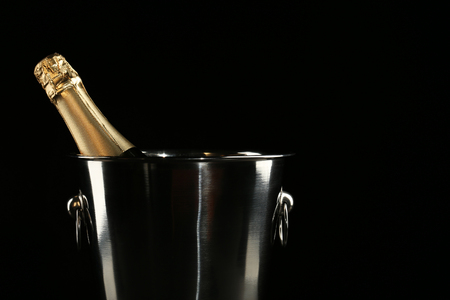 Champagne bottle in bucket on black backgroundの写真素材