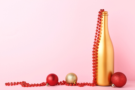 Decorated champagne bottle with christmas baubles on pink backgroundの写真素材