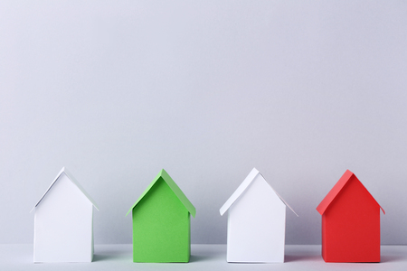 White, red and green paper houses on grey backgroundの写真素材