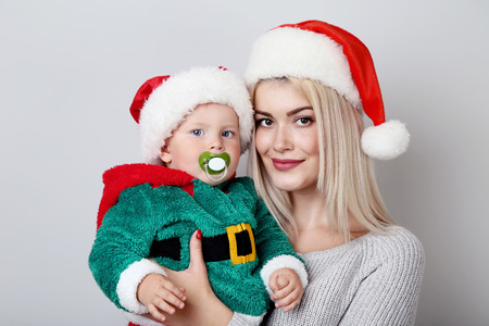 Mother and baby in santa hats on grey backgroundの写真素材