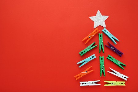 Colorful pins in shape of christmas tree on red backgroundの写真素材