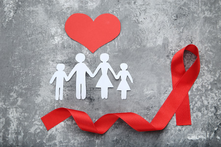 Red ribbon with paper family and red heart. Medicine conceptの写真素材