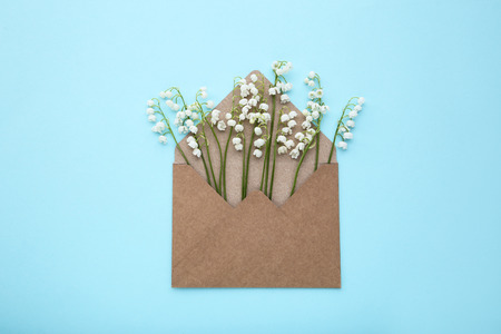 Lily of the valley flowers with envelope on blue backgroundの写真素材
