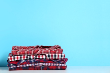Stack of folded shirts on blue background