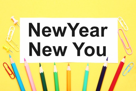 New year new you on sheet of paper with clips and colorful pencilsの写真素材