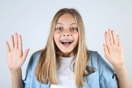 Young smiling girl with dental braces on grey backgroundの写真素材