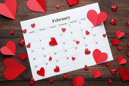 Red hearts with white february calendar on wooden tableの写真素材