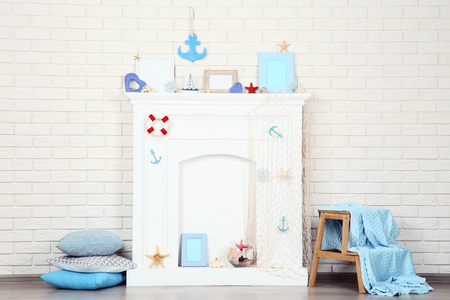 White fireplace with seashells, photo frames and pillowsの写真素材