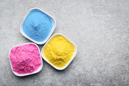 Colorful holi powder in bowls on grey backgroundの写真素材