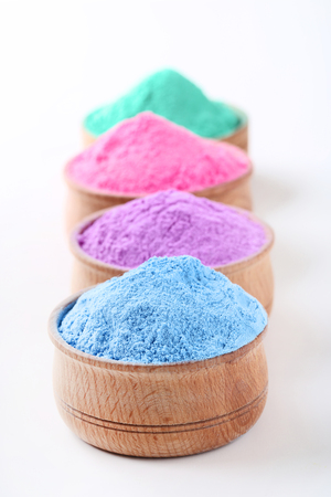 Colorful holi powder in bowls on white backgroundの写真素材