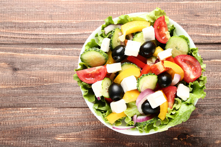 Vegetable salad in bowl on brown wooden tableの写真素材